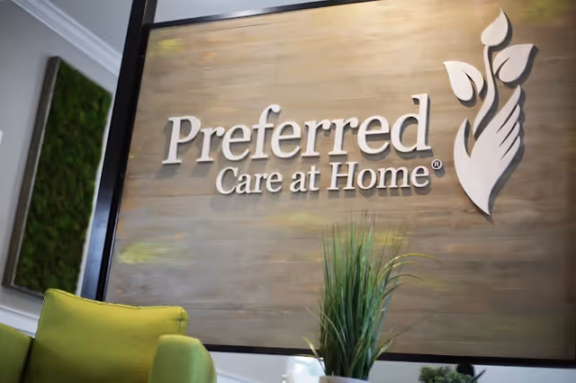 Interior lobby with wall sign reading 'Preferred Care at Home' and a plant.