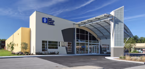 Modern medical facility exterior with curved glass entrance and signage for Akron Children's Sports Rehab
