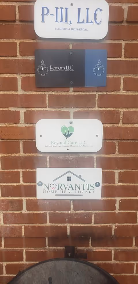 Brick exterior wall with multiple facility signs including Norvantis Home Healthcare.