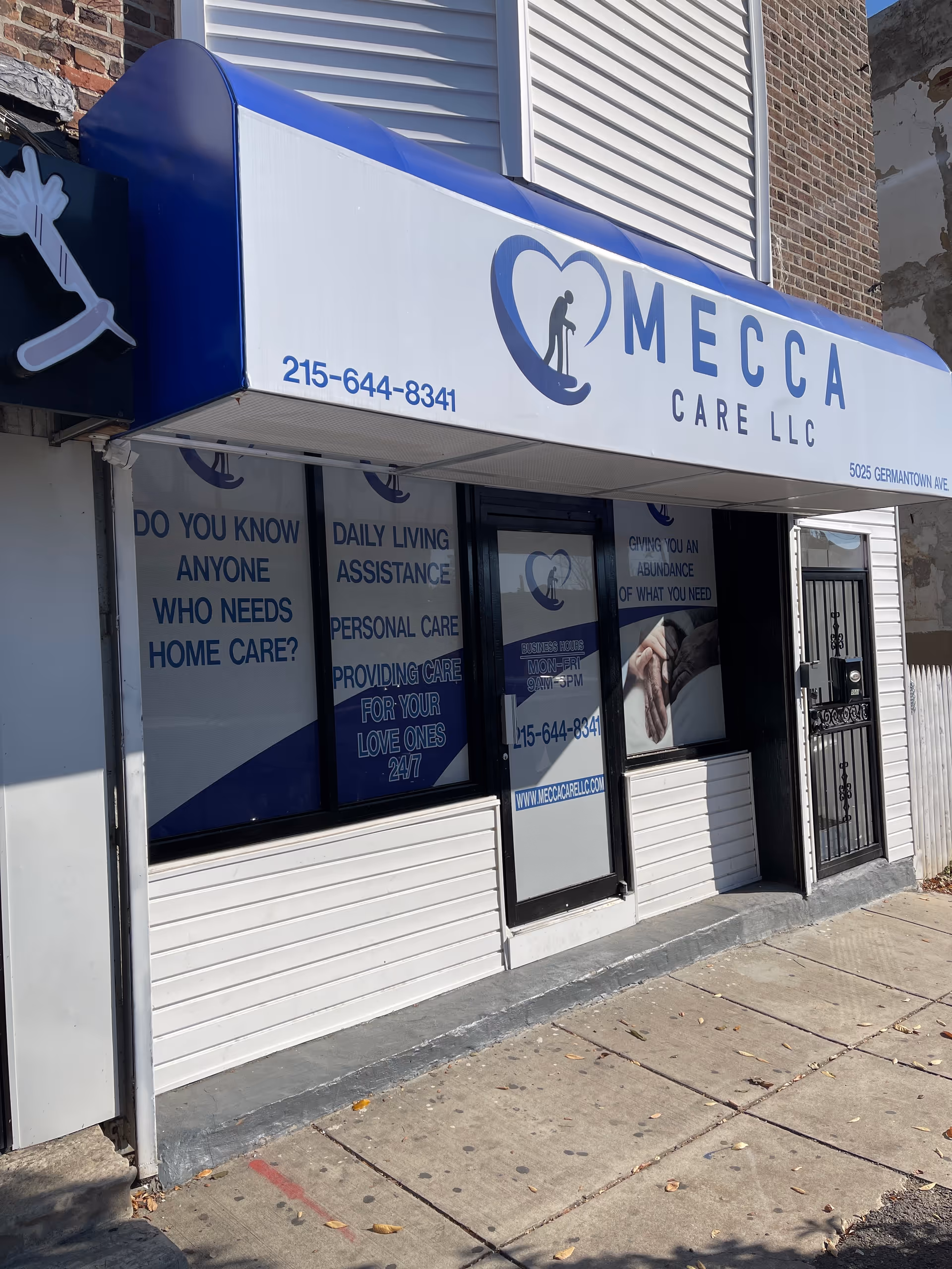 Front of Mecca Care LLC building with blue signage and storefront windows