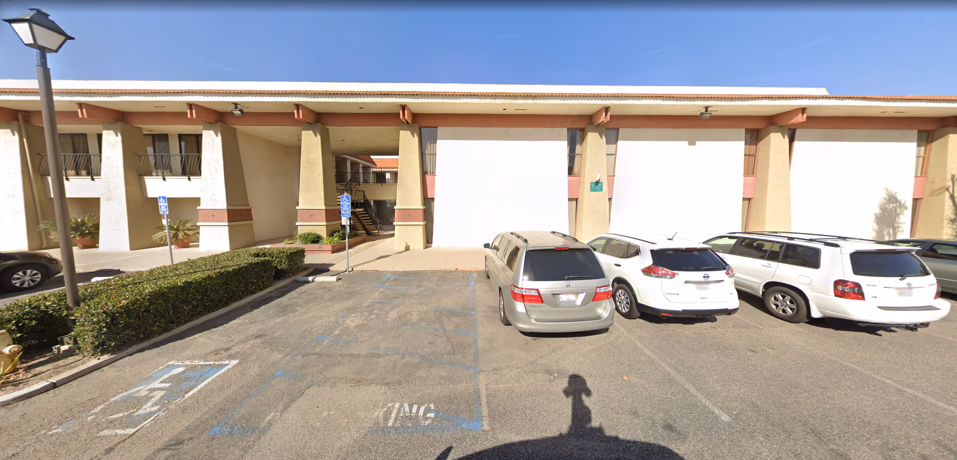 Front view of Devoted Care Services facility with a parking lot and cars.