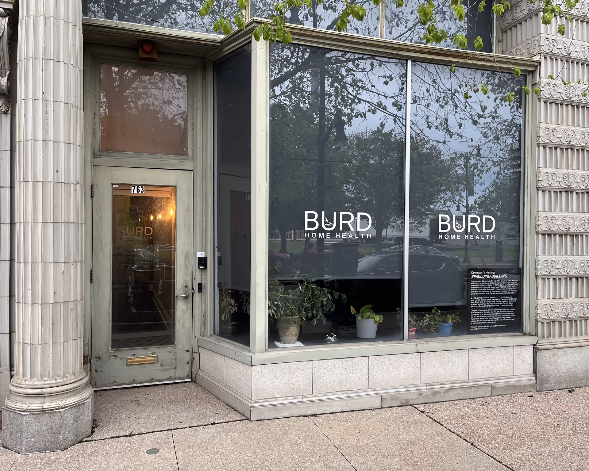 Storefront with Burd Home Health signage and glass windows, green door.