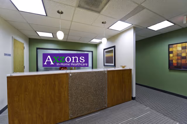 Interior reception area with wood front desk and Axzons In-Home Healthcare sign.