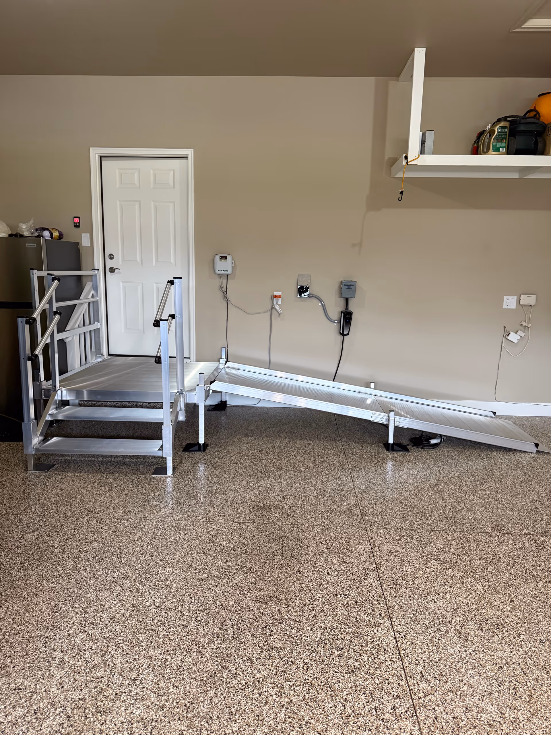 An interior utility area featuring a metal wheelchair ramp and a white door.