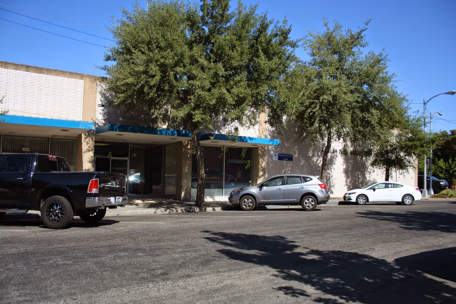 Kaweah Health Home Health building exterior with blue awnings and parked cars.
