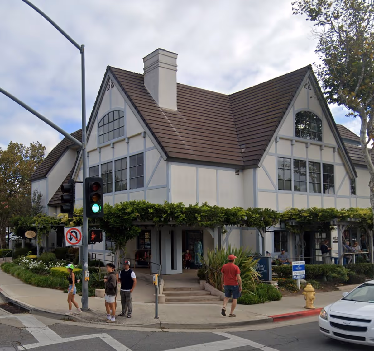 Tudor-style building on a busy street with pedestrians nearby