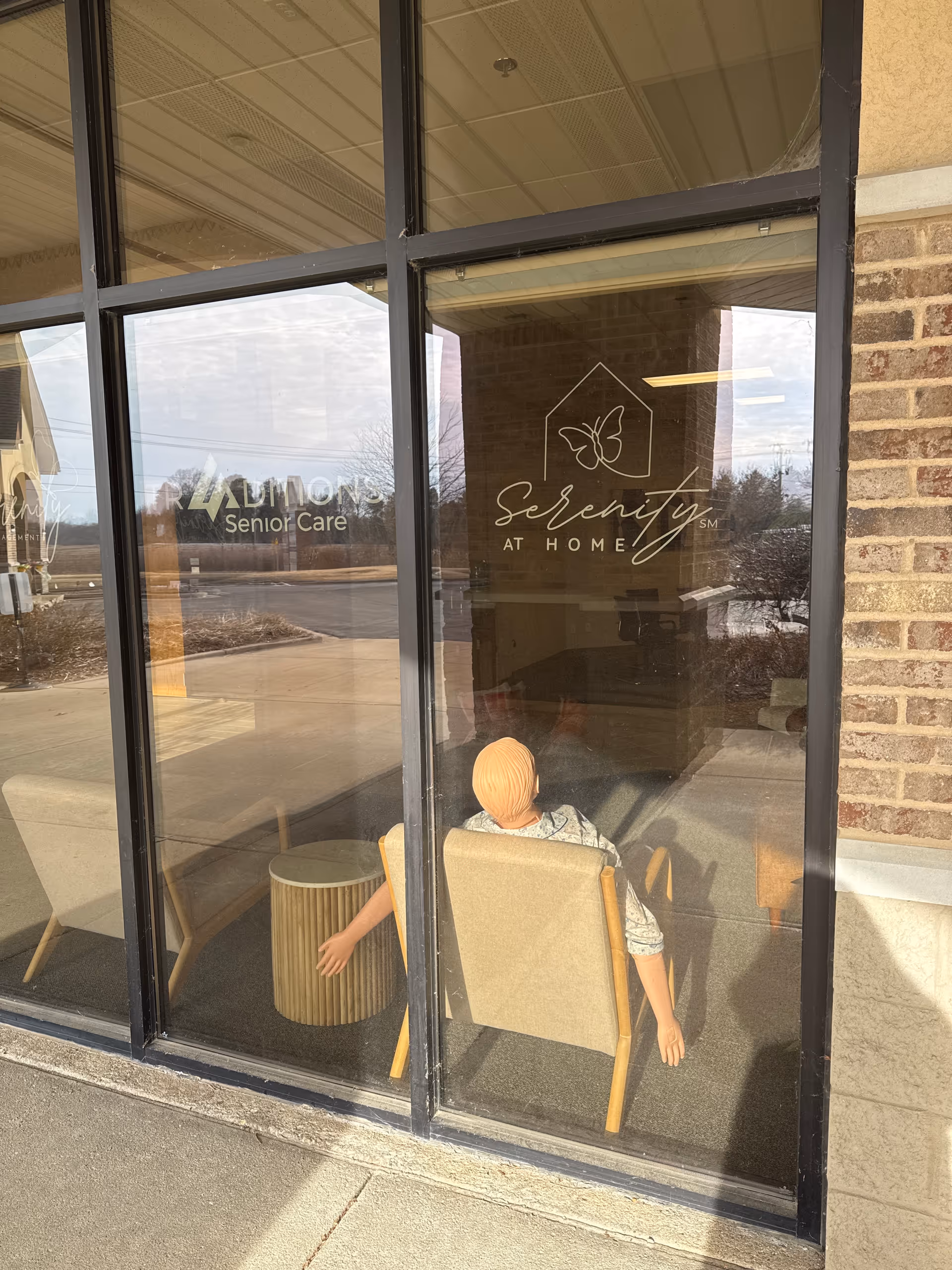 Inside Serenity at Home, glass storefront shows seating area and a resident silhouette.