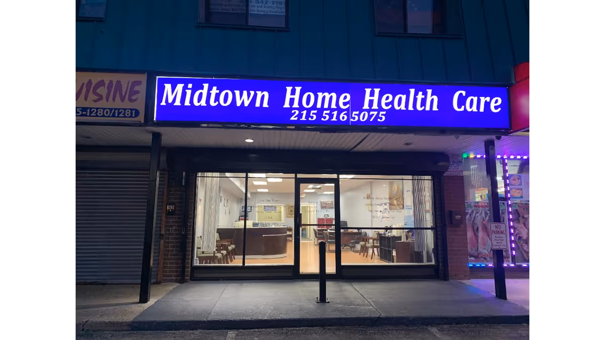 Blue-lit Midtown Home Health Care sign above glass storefront with interior seating visible.
