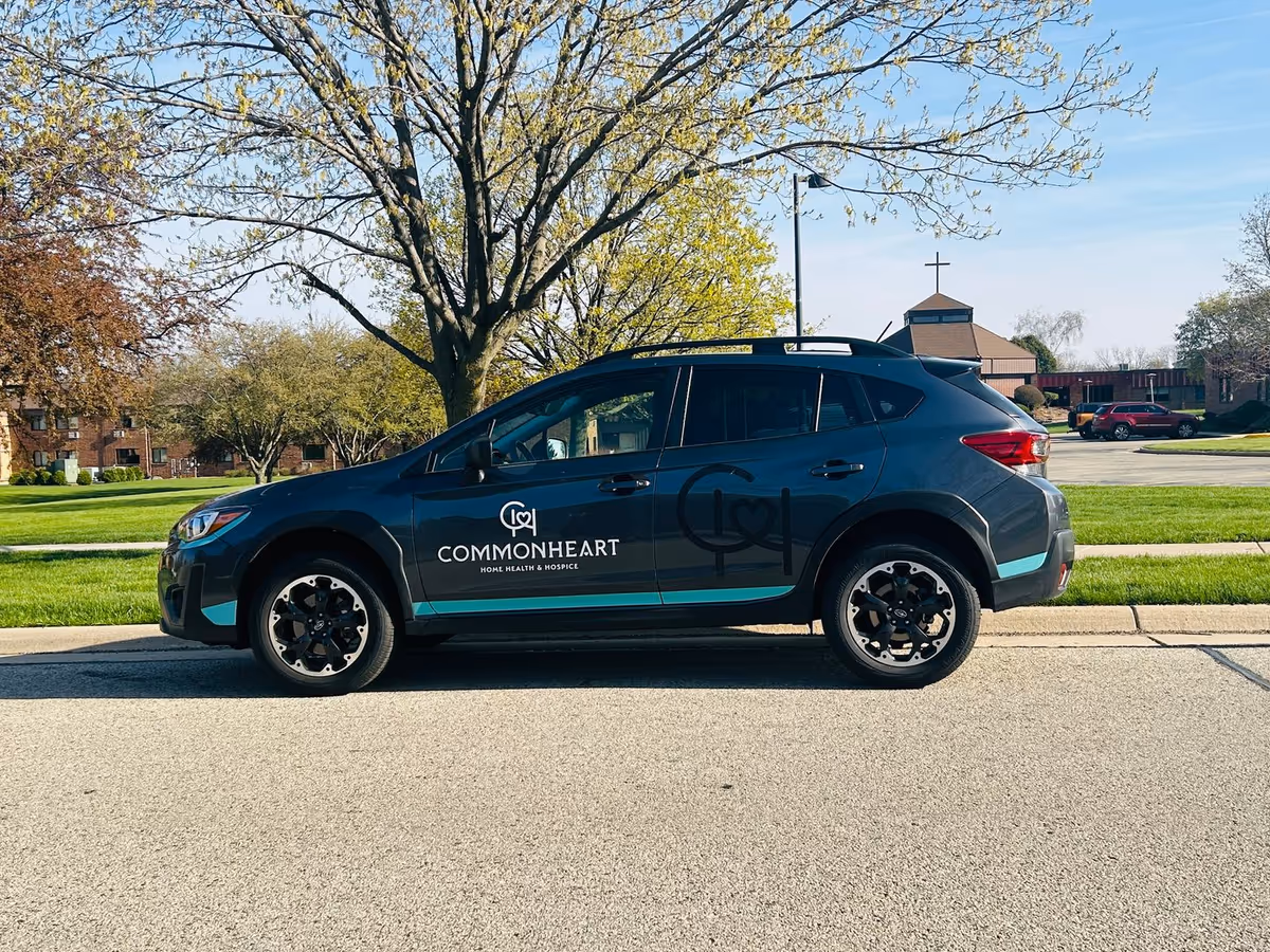 Branded Commonheart vehicle parked on a street with a church in the background.